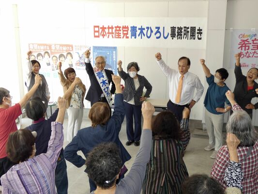 拳を上げる青木氏（後列左から３人目）＝１３日午前、宇都宮市宮本町