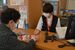 来店客に対応する代理店のスタッフ（右）。遠方を含め旅行の予約が好調という＝１４日午後、宇都宮市池上町