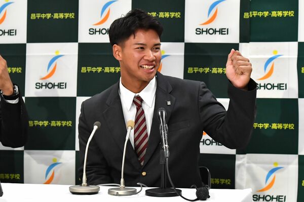 ロッテから４位指名を受けた昌平高の桜井。駆け付けた母リンダさんにガッツポーズする＝埼玉県杉戸町の昌平高、内藤大地撮影
