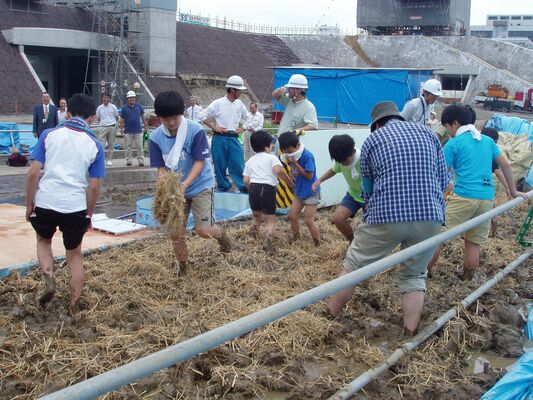 土塀に使う壁土を足でこねる子どもたち（宇都宮市公園管理課提供）