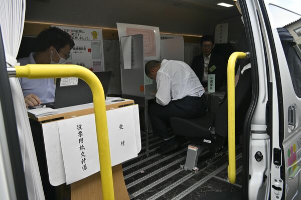 移動期日前投票所で投票する生徒ら＝16日午後、日光市瀬尾
