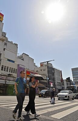強い日差しの下、半袖姿で日傘を差す通行人ら＝17日午後２時30分、宇都宮市馬場通り１丁目
