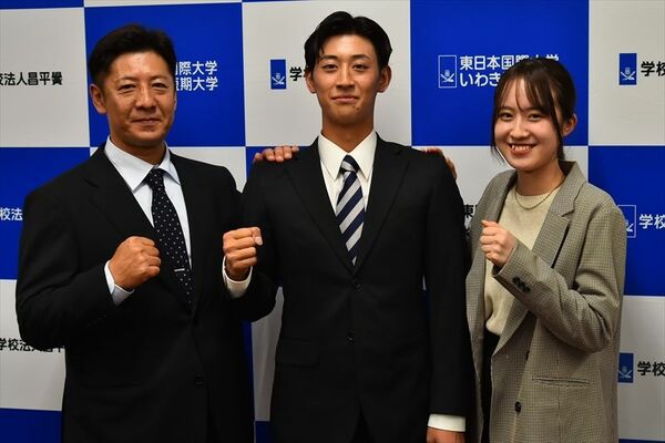 ソフトバンクから６位指名を受け、笑顔を見せる東日本国際大の大山（中央）と、父栄幸さん（左）、妹の大高葵さん＝福島県いわき市の東日本国際大