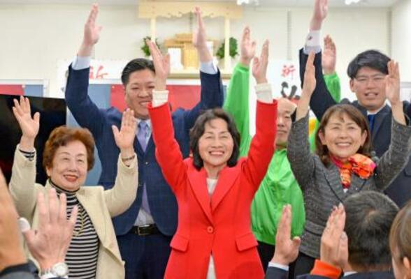 　東京１４区で当選確実を決め、万歳する自民党の松島みどり氏（中央）＝８日夜、東京都墨田区
