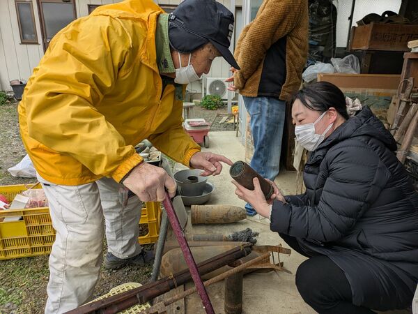 磯田さん(左)が所有する戦争関連資料を調査する県立博物館学芸員の小栁さん=2024年12月、佐野市内