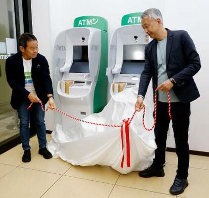 ファミリーマートの店内でATMをお披露目する同社の小谷健夫社長(左)と、セブン銀行の松橋正明社長=1日午前、東京都港区