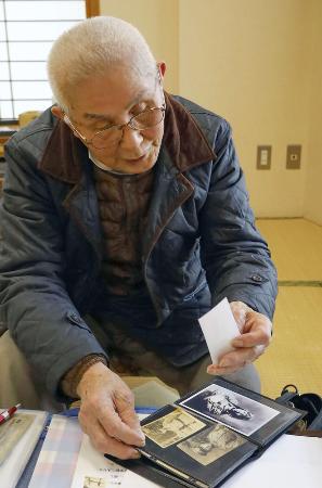 　太平洋戦争中の写真を眺める上野辰熊さん＝２０２５年２月、埼玉県新座市