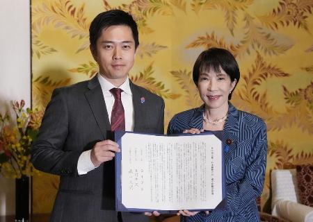 　10月20日、連立政権合意書を報道陣に示す自民党の高市早苗総裁（右）と日本維新の会の吉村洋文代表。衆院議員定数について「１割を目標に削減するため、臨時国会に議員立法案を提出し、成立を目指す」と明記した＝国会