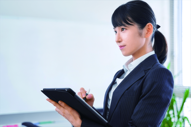 タブレットを持つスーツ姿の女性