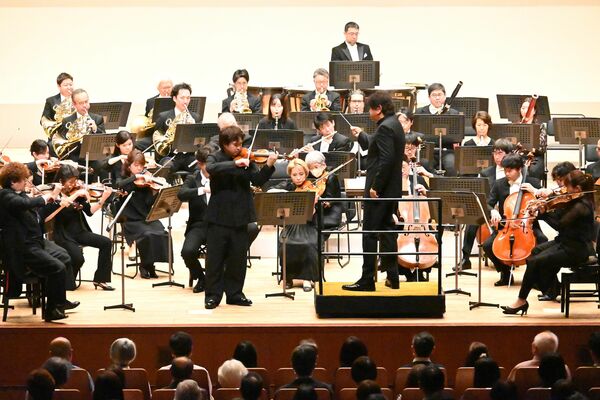 ブラームスのバイオリン協奏曲を演奏する三浦さん(中央左)と佐渡さん(中央右)=24日午後、県総合文化センター
