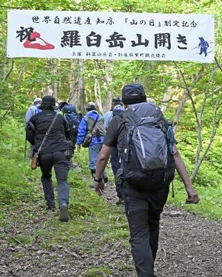 　山開きが行われた羅臼岳の岩尾別登山口から登山に向かう人たち＝５日早朝、北海道斜里町