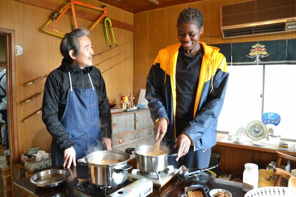 自国の香辛料を使い、しもつかれをアレンジするグレイスさん（右）