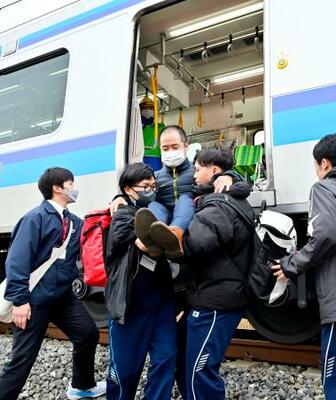 JR仙石線で実施された津波を想定した避難訓練で列車から降りる乗客役=26日午後、宮城県東松島市