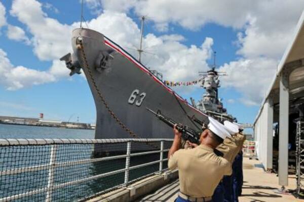 　日本が降伏文書を調印した戦艦ミズーリのそばで、礼砲を撃つ米海兵隊員ら＝２日、米ハワイ州真珠湾の埠頭（ロイター＝共同）