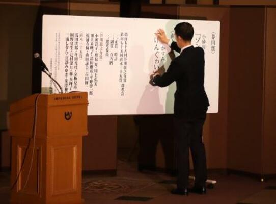 直木賞の受賞作を張り出す担当者。若林さんの落選が決まった瞬間だった=7月15日夜、東京都内