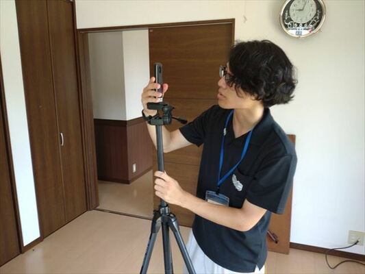 室内を３６０度カメラで撮影する長岡さん