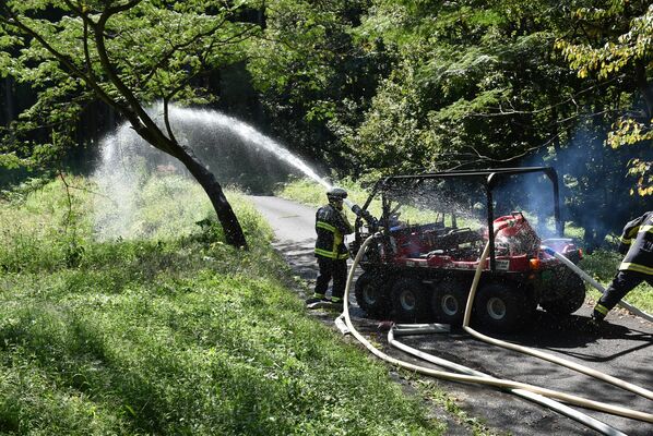 水陸両用バギーから放水する消防隊員ら
