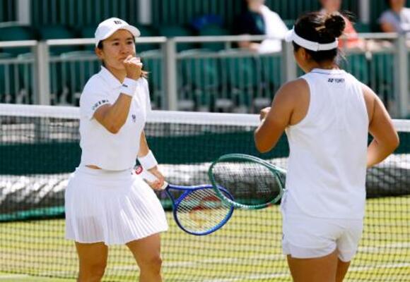 　女子ダブルス３回戦でポイントを奪い、ガッツポーズする青山修子。右は梁恩碩＝ウィンブルドン（共同）