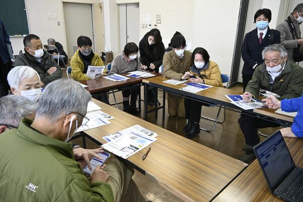 スマートフォンでの乗車予約方法の説明を受ける参加者ら