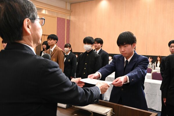 若菜理事長（左）から証書を受け取る奨学生＝２日午前、宇都宮市本町