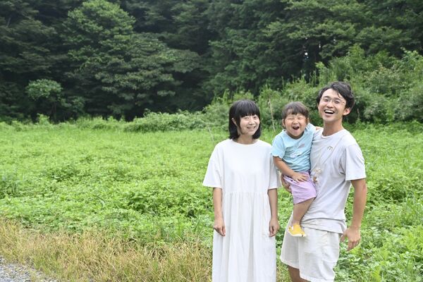 自然農法の畑に立つ（右から）高橋さん、唯愛ちゃん、輪奏さん
