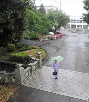宇都宮女子高正門近くの「操橋」を渡る大塚房子さん。太平洋戦争開戦時、万歳をした講堂は写真奥の辺りにあった=3日、宇都宮市操町
