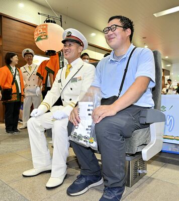 人気の１８５系の椅子を落札し笑顔の鉄道ファン＝30日午後２時45分、ＪＲ小山駅