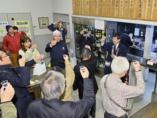 閉館を惜しみつつ、尾崎会長（右奥）の音頭で乾杯する日本酒ファンら＝31日午後５時５分、宇都宮市本町