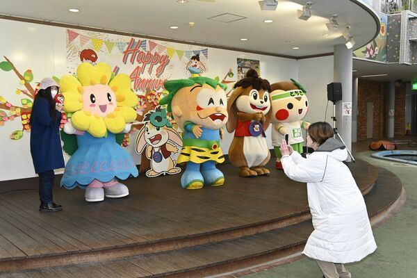 マスコットキャラクターと写真撮影する利用者