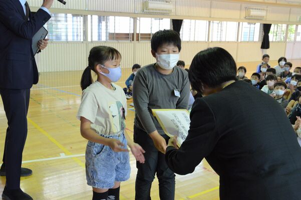 川俣市長に浄財を手渡す児童（中央）