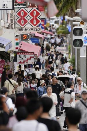 観光客らが行き交う那覇市中心部の国際通り=2024年6月