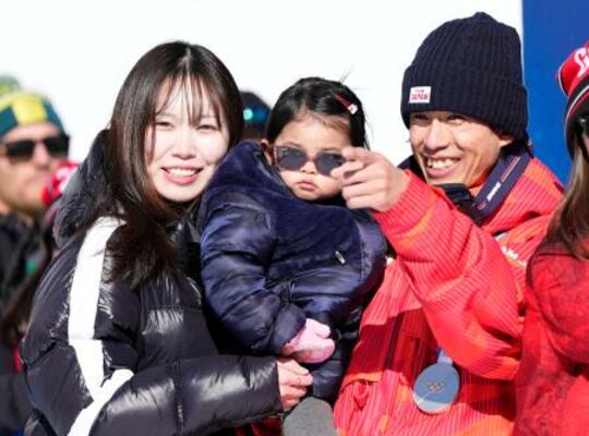 　フリースタイルスキー男子デュアルモーグルで獲得した銀メダルを胸に、妻の輝紗良さん（左）と喜ぶ堀島行真＝１５日、イタリア・リビーニョ（共同）