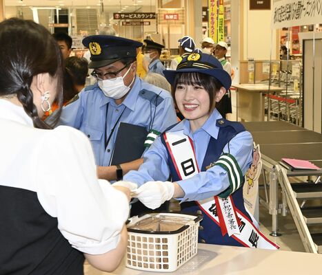 イベントの来場者に啓発品を手渡す森戸さん＝20日午前、宇都宮市陽東６丁目