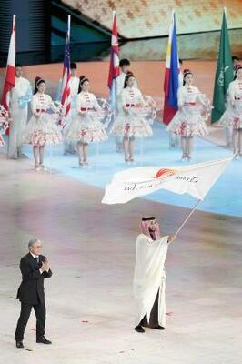 昨年2月、ハルビン冬季アジア大会の閉会式で、次回開催地のサウジアラビアの関係者に引き継がれた大会旗=中国・ハルビン