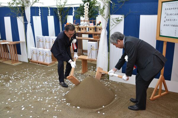 起工式でくわ入れを行う関係者