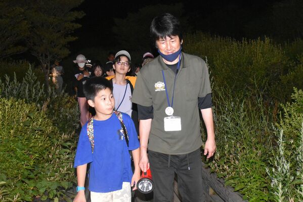 職員の先導で、ナイトハイキングをする子どもたち