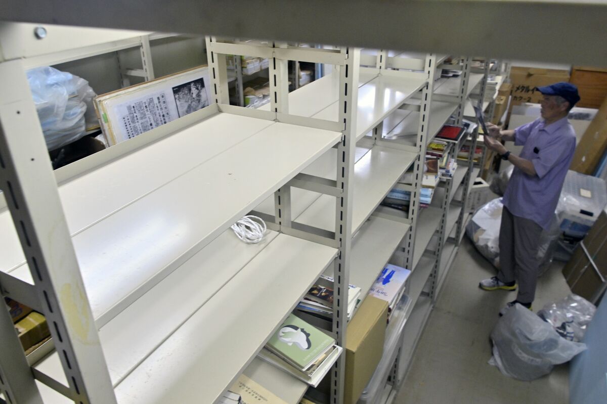がらんどうとした倉庫の棚を整理する田中さん＝７月31日午前、宇都宮市中央生涯学習センター