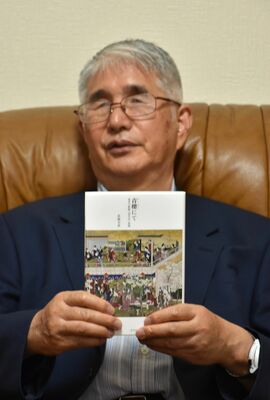 出版された小説「青樓にて」を持つ石川さん