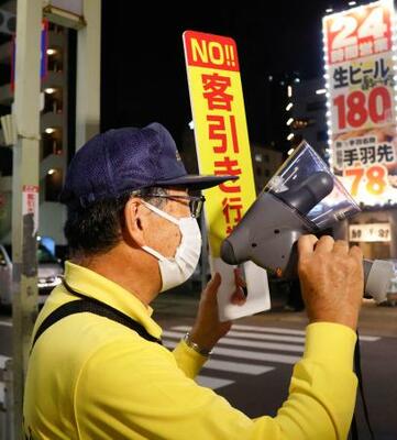 　名古屋駅周辺で、客引きに対し注意喚起する指導員＝３日夕