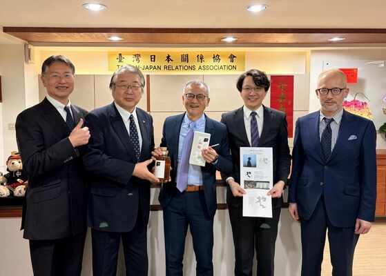 ウイスキーを贈る西堀和男社長（左から２人目）と受け取る簡志宇協会経済組長（中央）＝２月１３日、台北市