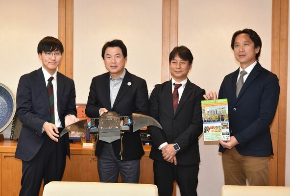 小型ロボットを手にする佐藤市長（左から２人目）と学会関係者