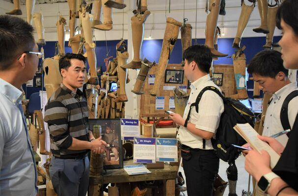 不発弾被害の悲惨さ、義足が必要とされる実態などを説明するカムチャンさん（左から２人目）＝７日午後、首都ビエンチャン