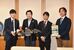 小型ロボットを手にする佐藤市長（左から２人目）と学会関係者