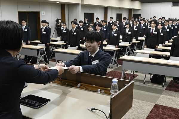 新入行員を代表し辞令を受け取る足利銀行高崎支店の高木康葉さん（中央）＝１日午前、宇都宮市
