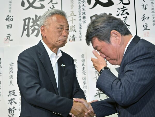 激戦を制し感極まる高橋氏（左）と茂木氏＝20日午後10時40分、宇都宮市戸祭町