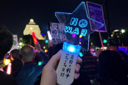 　漫画家・藤岡拓太郎さんがデザインしたペンライトを国会議事堂に向ける私＝筆者提供