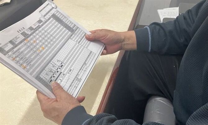 運転日報を手に「待機時間が休憩となるのはおかしい」と訴える男性＝１月、福岡市