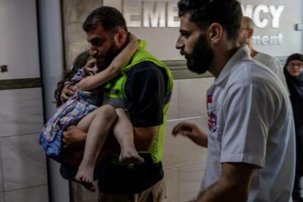 20日、レバノン南部の病院で、イスラエルによる攻撃で負傷した少女を搬送する人(ロイター=共同)