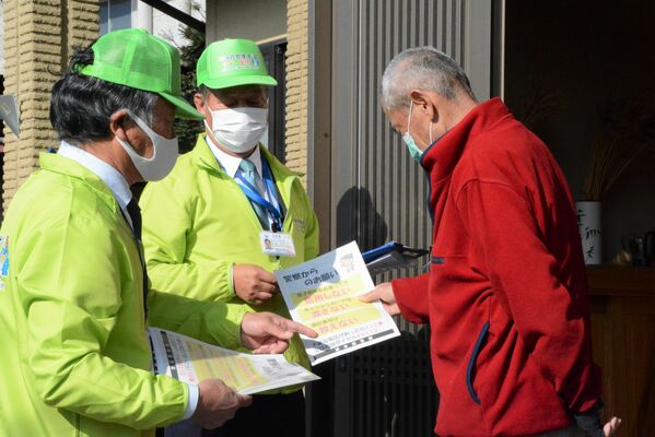 戸別訪問で特殊詐欺被害防止を呼びかける岸田隊長（中央）ら＝１８日午前10時、宇都宮市徳次郎町