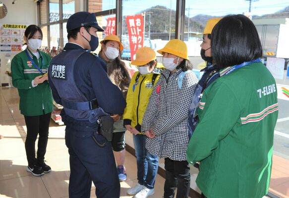 コンビニに駆け込み、警察官に事情を話す大月小の子どもたち